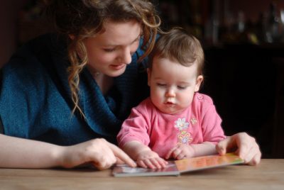 woman teaching baby to read