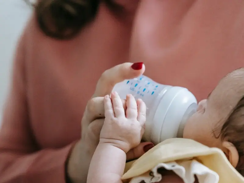 Professional maternity nurse supporting a newborn baby and new mother at home in London