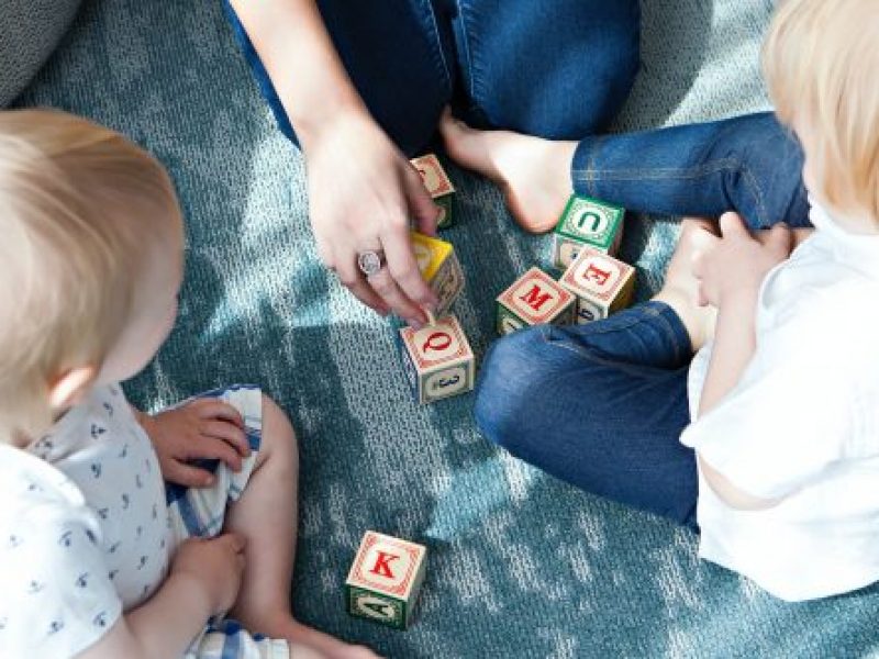 two toddlers with alphabet blocks