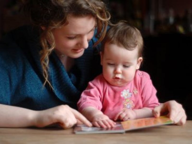 woman teaching baby to read