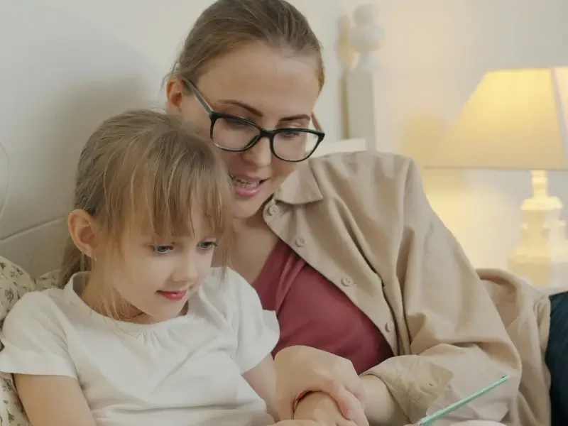 Professional nanny settling a young child to sleep with a calm and consistent bedtime routine at home in London