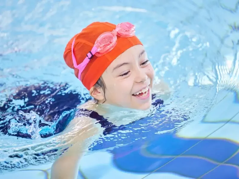 Professional nanny accompanying a child to swimming lessons in London as part of their daily routine